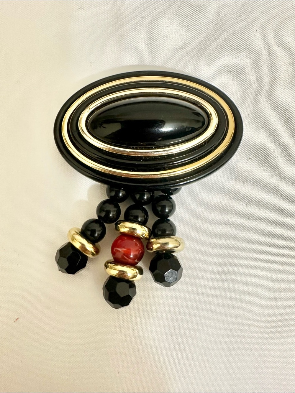 Black and Gold Oval Beaded Tassel Brooch with Red Accent